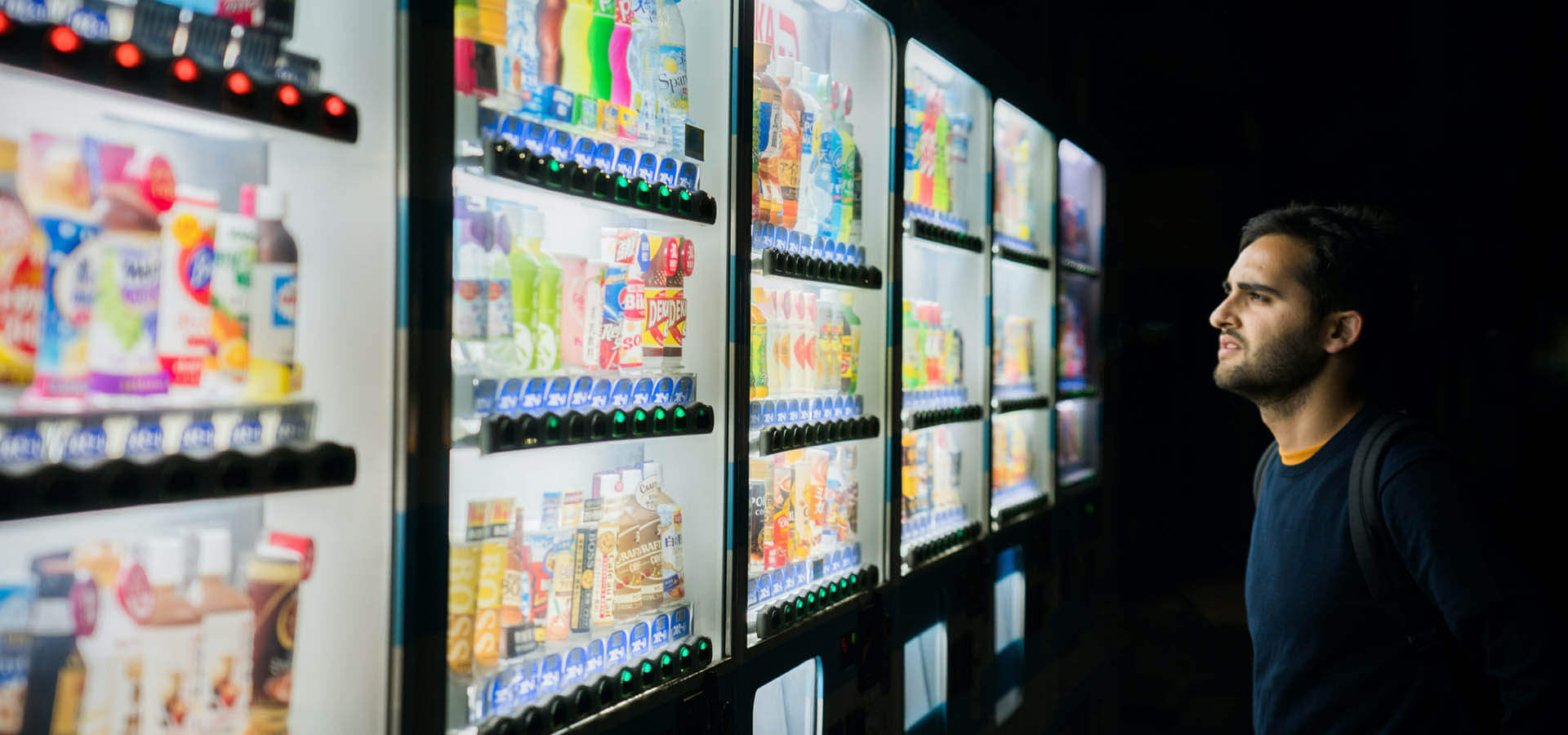 Man looking at drinks in vending machines